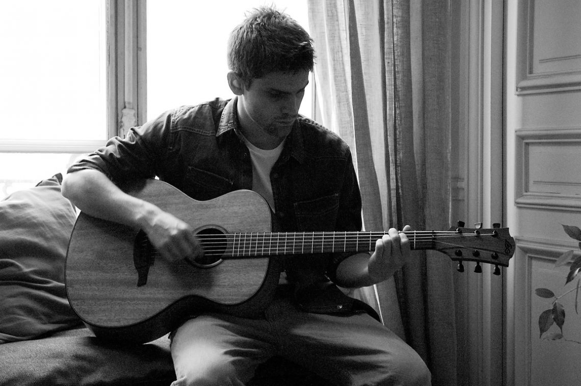 L'Américain Day 3 Lead actor playing guitar